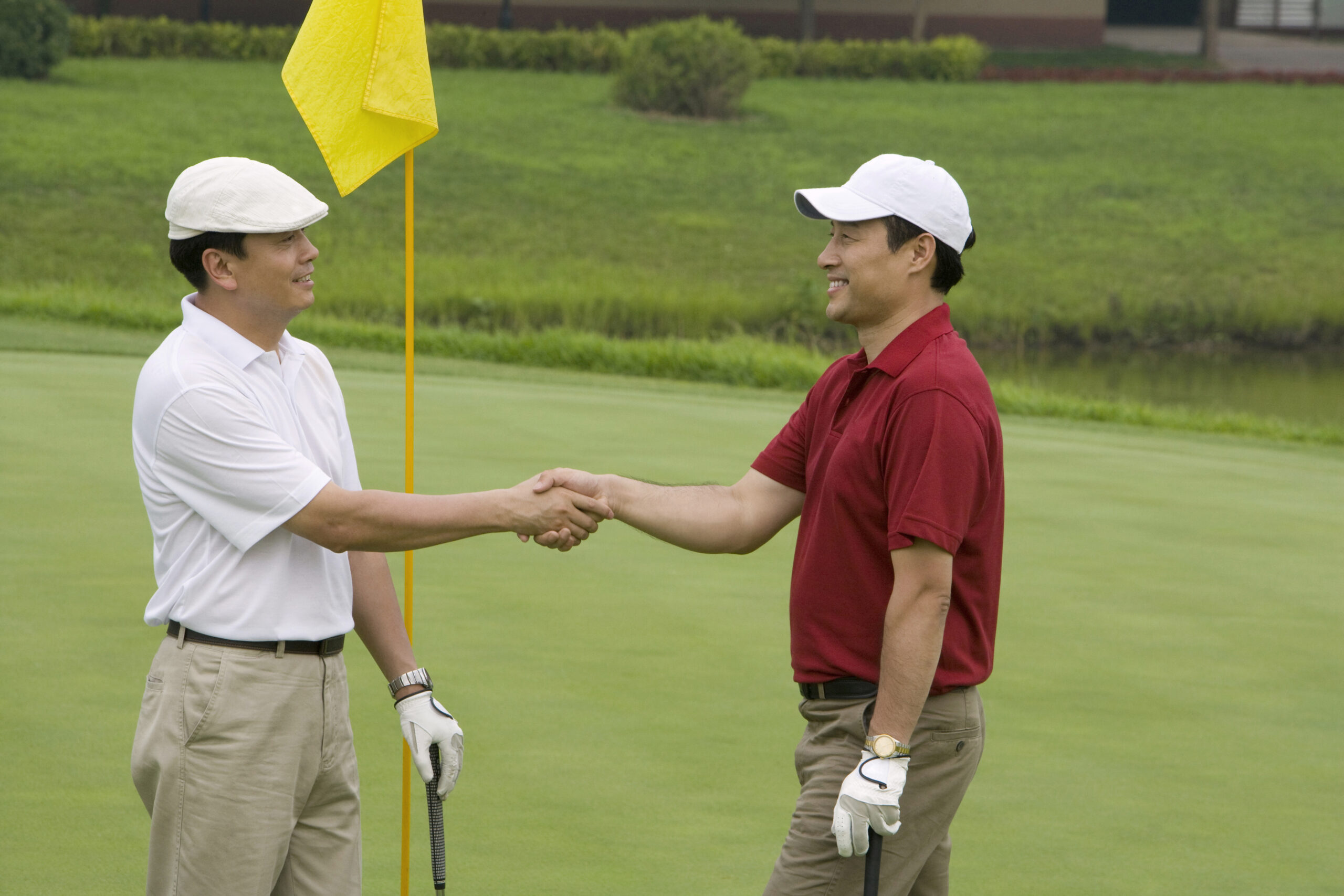 Two golfers shaking hands over a business deal